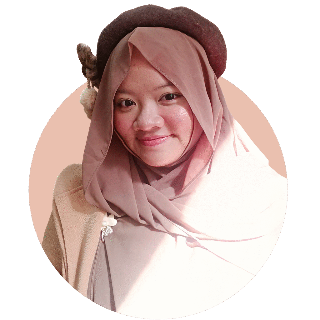 A photo of Kinanty Andini wearing a soft brown hijab and a dark brown beret with decorative accents, smiling gently at the camera. She is dressed in neutral tones and is photographed against a soft, light brown-colored circular background.